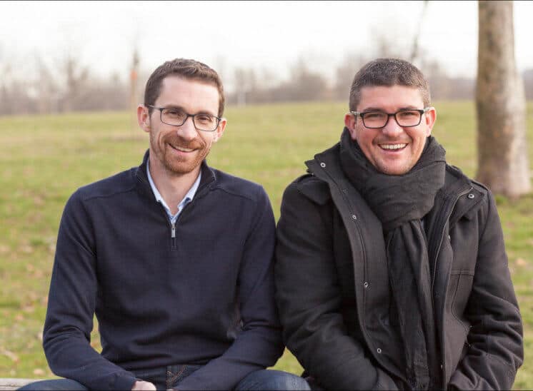 Deux frères assis sur un banc rigolent devant le photographe