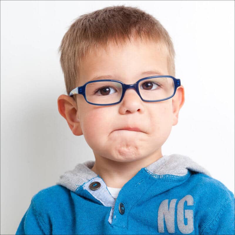 Un enfant fait une très jolie grimace. Il a un très jolie visage