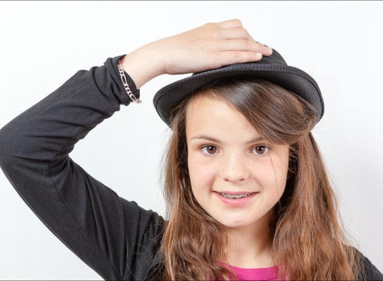 Une jeune fille a saisit le chapeau sur sa tête pour le retirer