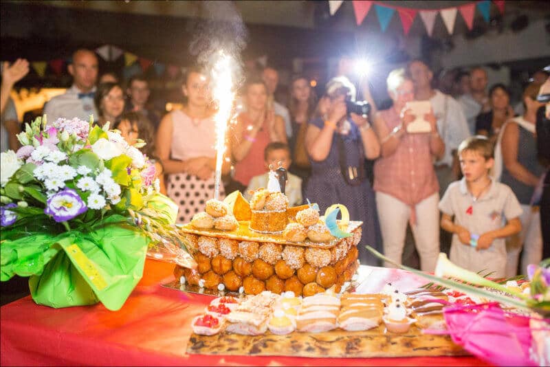 Le gateau des mariés, surmonté d'un feux, trône devant les invités du mariage