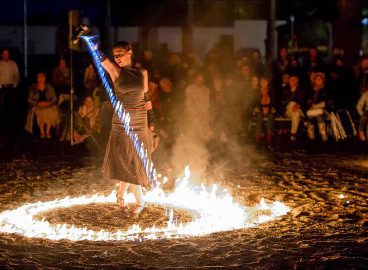 La danseuse de tango déverse de l'essence en flamme , formant un cercle de feu autour d'elle.