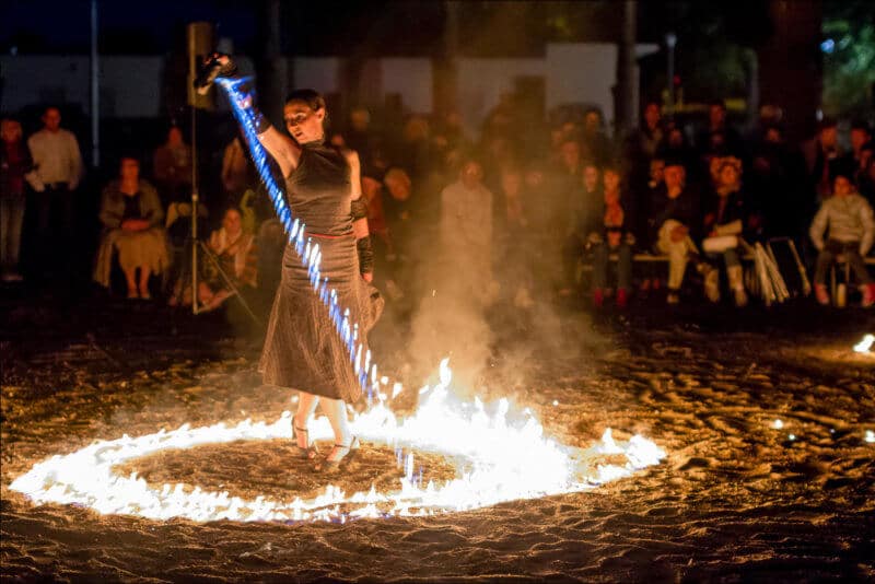 La danseuse de tango déverse de l'essence en flamme , formant un cercle de feu autour d'elle.