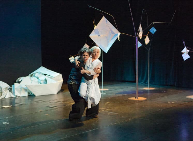Parmi une scène remplie de papiers posés au sol, les deux danseurs exécutent leur ballet avec grace
