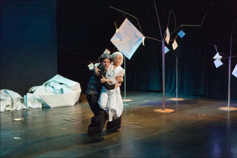 Parmi une scène remplie de papiers posés au sol, les deux danseurs exécutent leur ballet avec grace