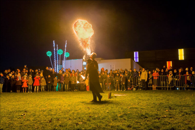 La foule encercle un craqueur de feu qui souffle dans flammes dans la nuit, devant la salle LES JUSTES au CENDRE