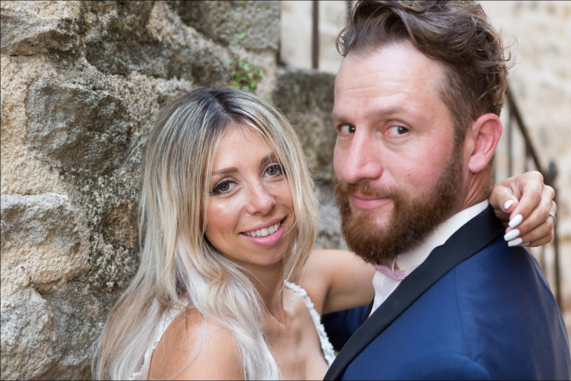 Les mariés tournent la tête et regardent le photographe