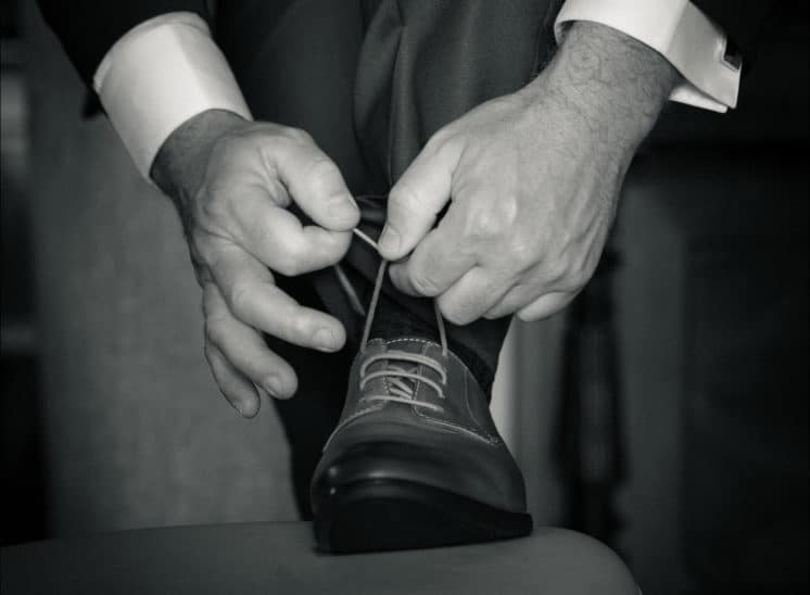 Le marié fait ses lacets de chaussure